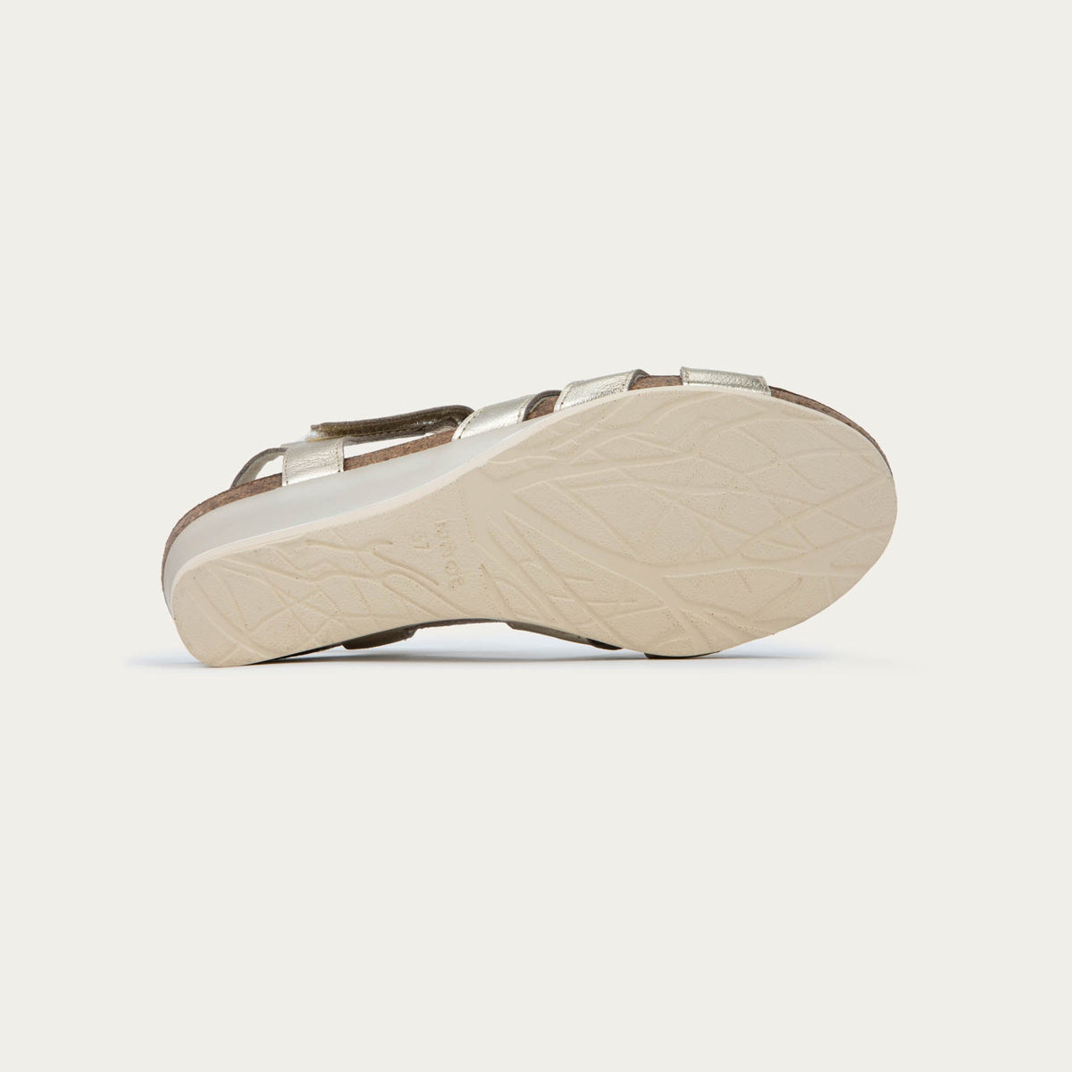 A pair of gold wedge sandals with strappy design, open toe, and adjustable ankle strap on a cork footbed.