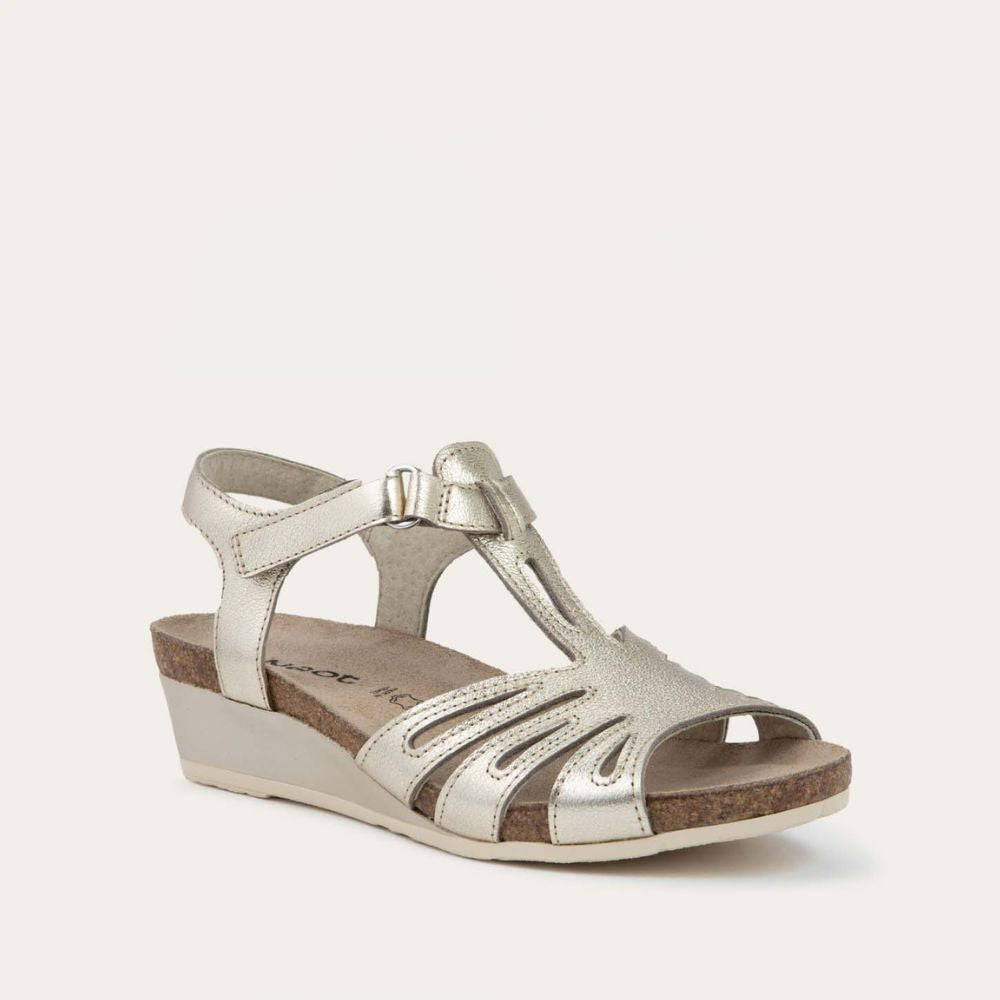 Top view of a gold wedge sandal with strappy design, open toe, and adjustable ankle strap on a cork footbed.