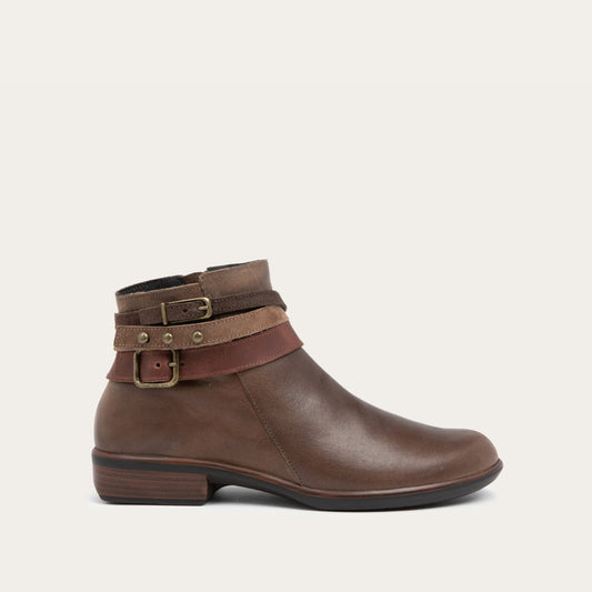 Side view of a brown leather ankle boot with two decorative straps and brass buckles. The boot has a low heel and a smooth, polished finish, conveying a stylish look.