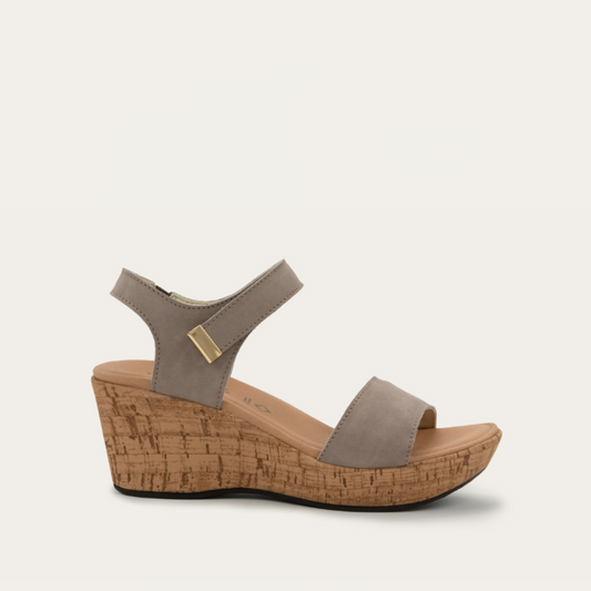 A beige platform wedge sandal with hook and loop strap and a cork sole.