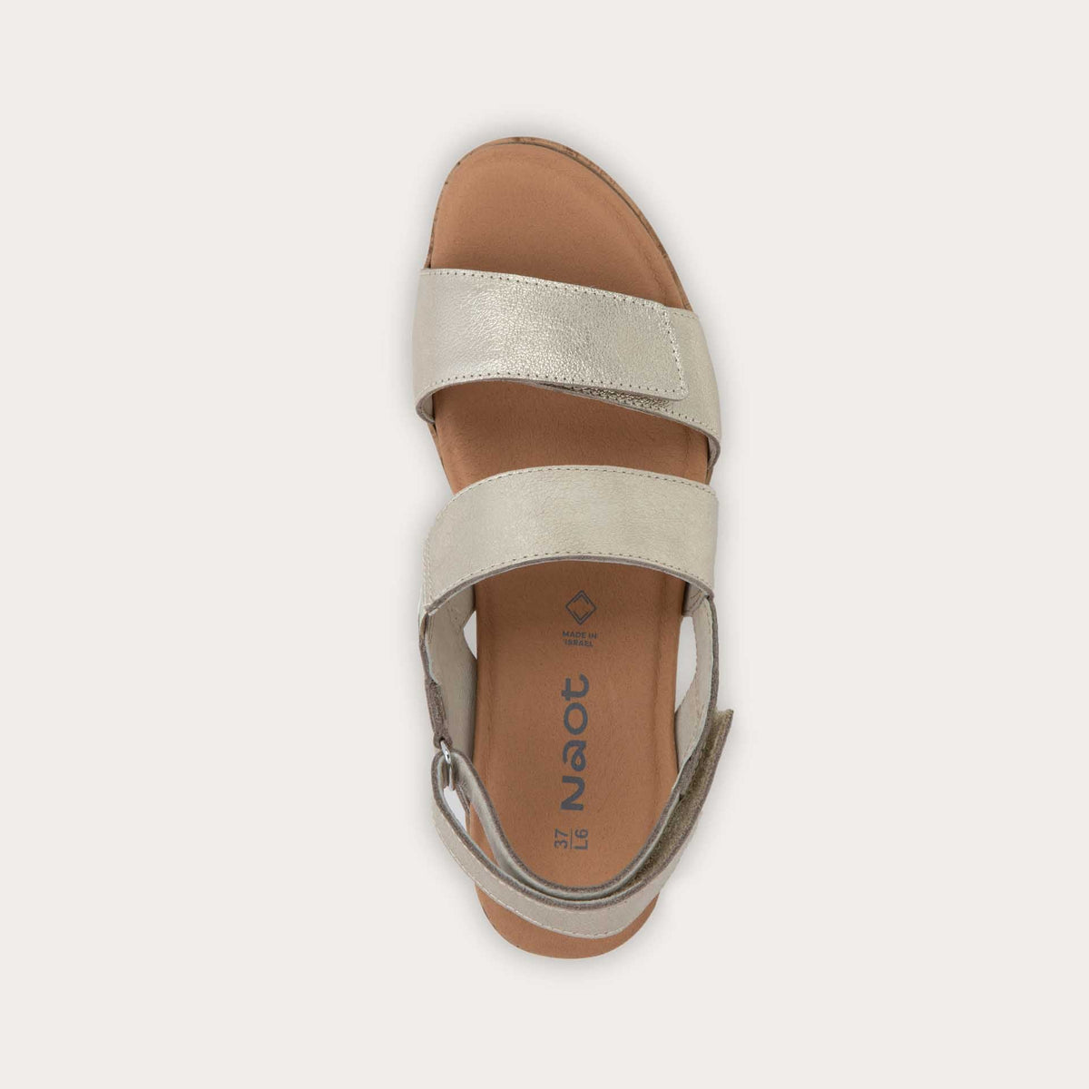 Top view of a gold sandal with metallic straps on a cork wedge sole. Features an open toe and wedge heel.