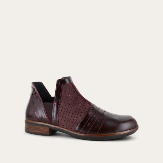 A brown ankle boot with a low heel and perforated designs, part of the Aura Collection.